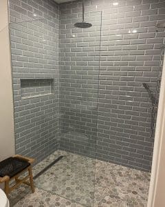 This image features a curbless shower with grey tile.