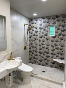 full bathroom remodel with gold accent hardware and floral accent tile in standing shower